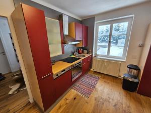 a kitchen with red cabinets and a sink and a window at Bergkuss Brunnalm Veitsch in Veitsch