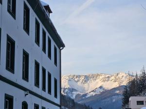a building with snow covered mountains in the background at Bergkuss Brunnalm Veitsch in Veitsch
