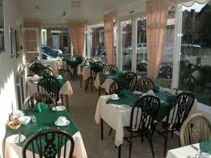 a restaurant with tables and chairs with green tablecloths at Silverdale Guesthouse in Keswick