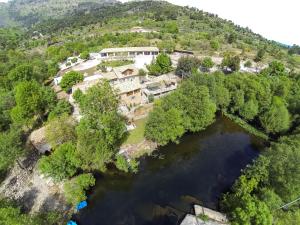 uma vista aérea de uma casa numa colina ao lado de um rio em Quinta Do Moinho Turismo de Natureza em Aldeia Viçosa