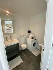 a bathroom with a toilet sink and a washing machine at Reihenhaus mit Garten und Terrasse an der Messe. in Hannover