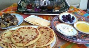 a table with plates of pancakes and bowls of food at désert tours & Hôtel Titanic lac irik in Foum Zguid