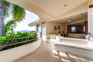 sala de estar con sofá blanco y cocina en Preciosa Villa en Marina Las Brisas, en Acapulco