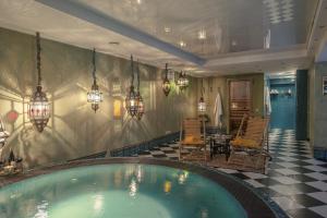 a swimming pool in a room with a table and chairs at Apvalaus Stalo Klubas Gastro & SPA Hotel in Trakai