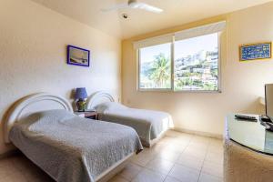 1 dormitorio con 2 camas y ventana en Preciosa Villa en Marina Las Brisas, en Acapulco