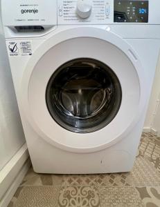 a white dryer with a washing machine in a room at BaMo Studio - city living arkaden in Klagenfurt