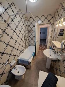 a bathroom with a bed and a sink and a toilet at Green House Olivedo in Varenna