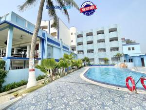 um resort com uma piscina em frente a um edifício em Hotel V-i sea view, puri private-beach-gym-spa fully-airconditioned-hotel lift-and-parking-facilities breakfast-included em Puri