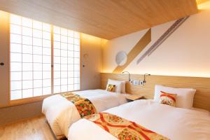 two beds in a room with two windows at Higashiyama Hills - Vacation STAY 41308v in Kyoto