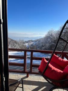 a hammock on a balcony with a view of the snow at Sunčani vrhovi in Raška