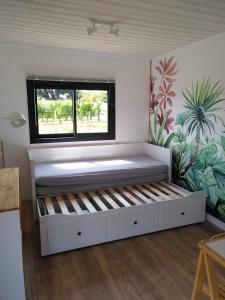 Bett in einem Zimmer mit Fenster in der Unterkunft Maison sur pilotis in Saint-Palais