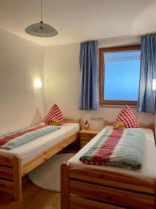 um quarto com 2 camas individuais e uma janela em Ferienwohnung Schoppernau em Schoppernau