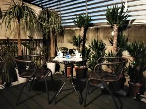 d'une terrasse avec une table, deux chaises et des palmiers. dans l'établissement YūshukuFushimi Inari - Vacation STAY 41346v, à Kyoto