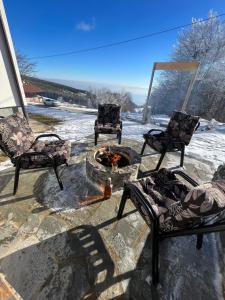 a patio with two chairs and a fire pit at Sunčani vrhovi in Raška
