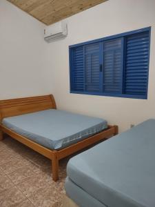 Zimmer mit 2 Betten und einem Fenster in der Unterkunft Sítio Cantinho da Cachoeira in Guapé