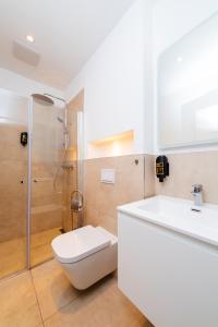 a bathroom with a toilet and a sink and a shower at City Rooms Dortmund in Dortmund