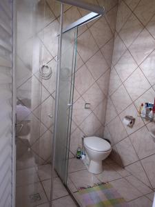 a bathroom with a toilet and a glass shower at Sítio Cantinho da Cachoeira in Guapé