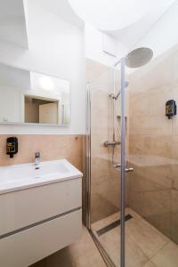 un baño con lavabo y ducha en City Rooms Dortmund, en Dortmund
