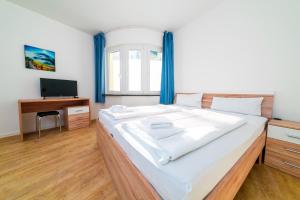 1 dormitorio con 1 cama grande y TV en City Rooms Dortmund en Dortmund