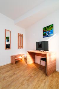 a desk with a television on top of it in a room at City Rooms Dortmund in Dortmund