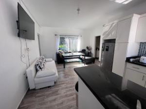 uma cozinha e sala de estar com um frigorífico e um sofá em Vázquez apartamentos em La Piña