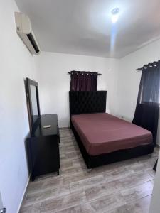 um quarto com uma cama, uma cómoda e um espelho em Vázquez apartamentos em La Piña
