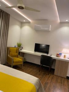 拉合爾的住宿－Rosewood Lahore，酒店客房设有一张床和一张带电视的书桌。