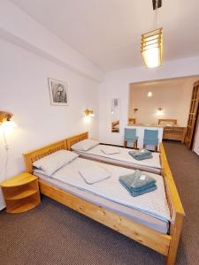 a bedroom with a large bed with two blue chairs at 7 Levél Panzió, Ultra Central, Self Check-in, Self-Catering in Miercurea-Ciuc
