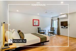 a hotel room with a bed and a table and chairs at Townhouse 165 Netaji Road in Ahmedabad
