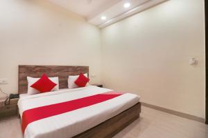 a bedroom with a large bed with red pillows at Flagship Comfort Residency Near Artemis Hospital in Gurgaon