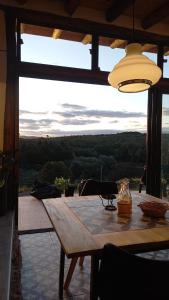 einen Holztisch in einem Zimmer mit Aussicht in der Unterkunft Cabaña La Emilia - Villa Giardino in Villa Giardino