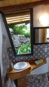 ein Badezimmer mit Waschbecken und Spiegel in der Unterkunft Cabaña La Emilia - Villa Giardino in Villa Giardino