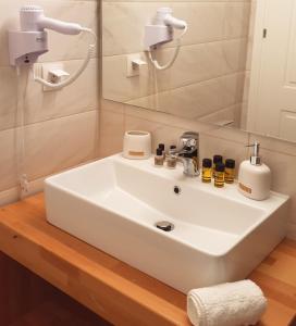 lavabo blanco en el baño con espejo en Reiki Apartments, en Ereikoússa
