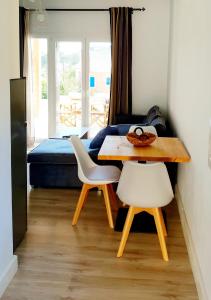 EreikoússaにあるReiki Apartmentsのテーブル、椅子2脚、ベッド1台が備わる客室です。