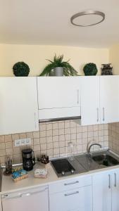 una cocina con armarios blancos y fregadero en Teide & Mar Vistas, en Tacoronte