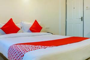 een groot wit bed met rode kussens erop bij Flagship Sbk Icon Near Fun Time Multiplex in Māngvādi