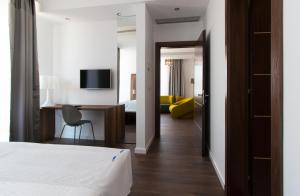 a hotel room with a bed and a desk with a chair at Perla Luxury in Ulcinj