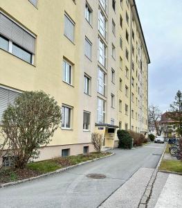an empty street in front of a tall building at BaMo Studio - city living arkaden in Klagenfurt