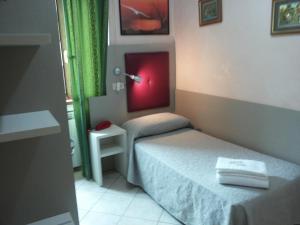 a small bedroom with a bed and a red light at Hotel Le Querce in Milan