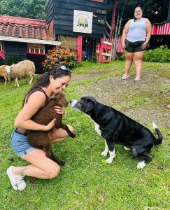 una mujer sosteniendo un perro y un perro en Rancho Makena, en Monteverde