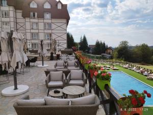 a hotel patio with chairs and a swimming pool at Wolf Apartments Kopaonik in Kopaonik