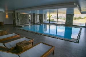 una gran piscina con una gran ventana en un edificio en Loi Suites Chapelco Hotel en San Martín de los Andes