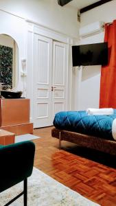 a living room with a blue couch and a tv at Plebiscito Suite Apartment in Naples