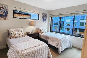 a bedroom with two beds and a large window at West Seattle's Modern Townhome in Seattle