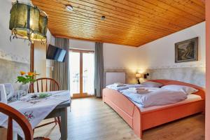 sypialnia z łóżkiem i stołem oraz jadalnia w obiekcie Gästehaus Eder Oberammergau w mieście Oberammergau