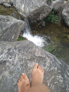 a person sitting on a rock near a waterfall at Cultura Serrana in La Paz +1 photo