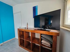 a living room with a tv and a wooden entertainment center at Attico Granelli di Sabbia in Lido di Ostia