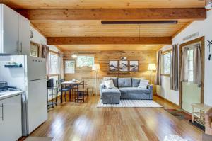 a living room with a blue couch and a kitchen at Arlington Creekside Cabin with Hot Tub and Fire Pit! in Arlington