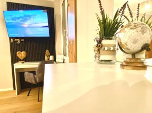 a room with a table with a globe and a tv at BaMo Studio - city living arkaden in Klagenfurt