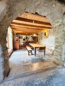 a dining room with a table and a stone wall at Подковите in Karlovo